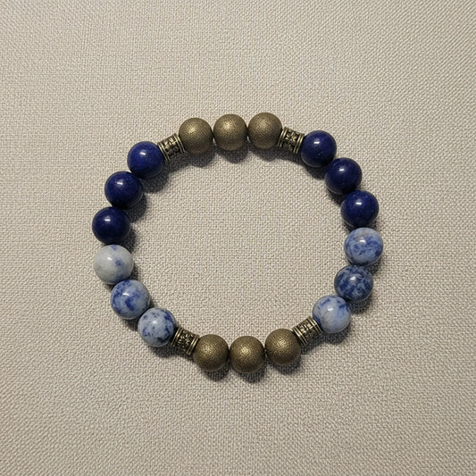 Beaded bracelet with blue and gold beads on a textured gray background
